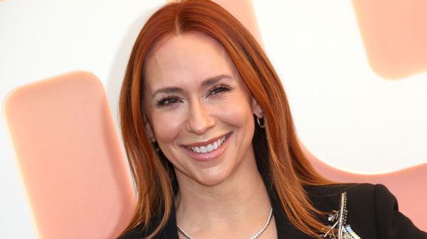 Jennifer Love Hewitt smiling in an embroidered black blazer